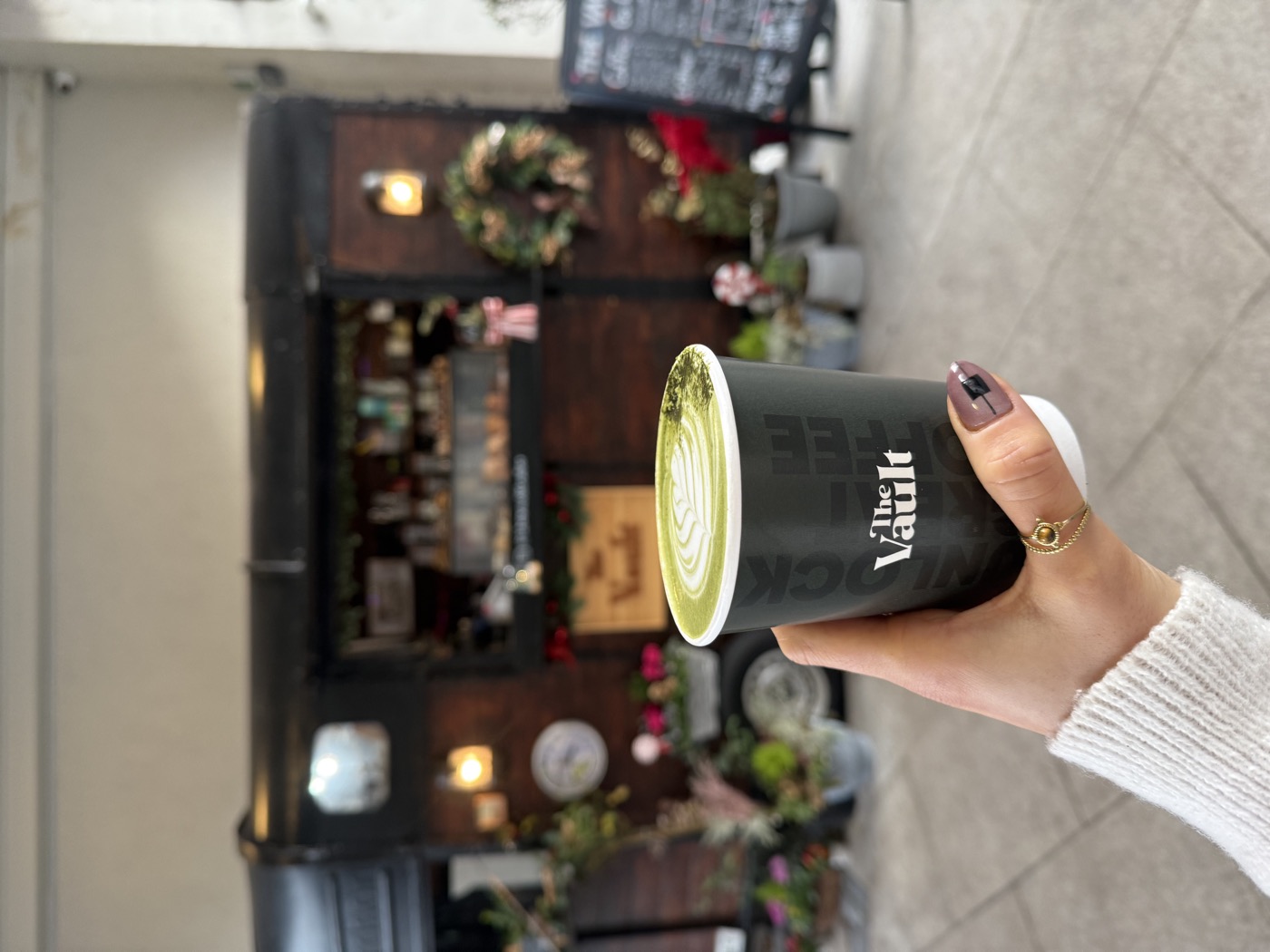 A matcha latte in a Vault cup in front of the Trailer