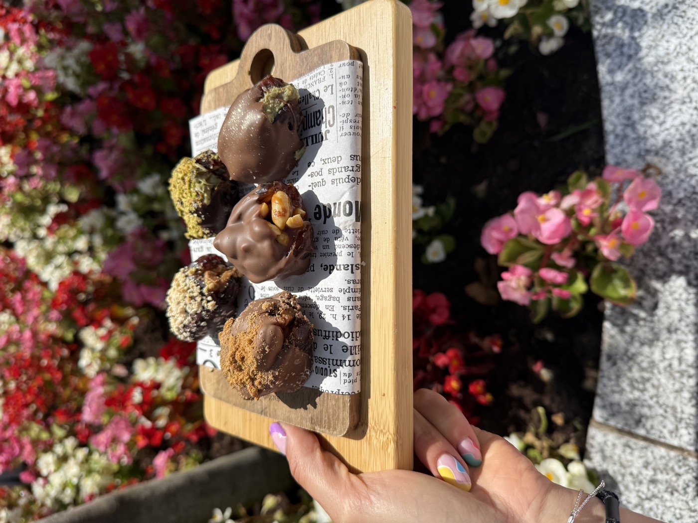 Protein balls on a wooden board among the flowers